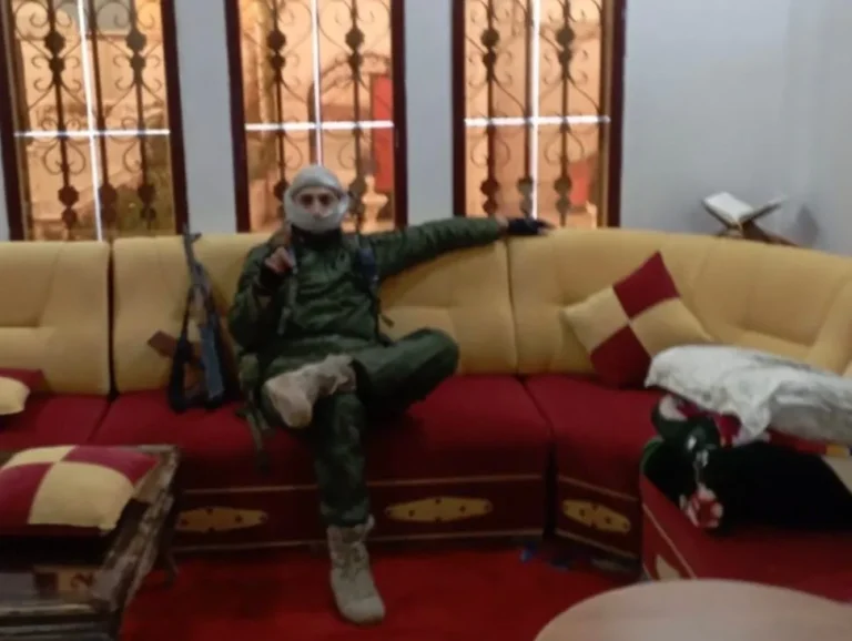 A Syrian rebel sitting in one of Assad's palaces during the 2024 offensive in Syria