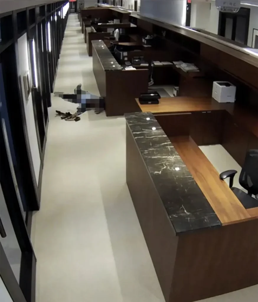 Image: Surveillance still from inside 345 Park Avenue shows the shooter Shane Tamura’s final position, weapon discarded beside the body. Image has been blurred for public sensitivity.