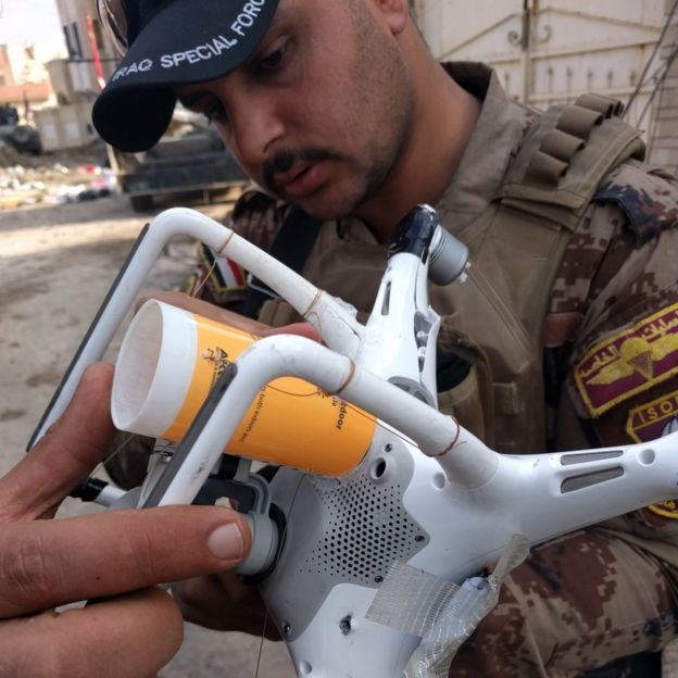 An image of a man holding an ISIS drone with a basic cup-holding mechanism for ordnance. Credit: https://twitter.com/MitchUtterback