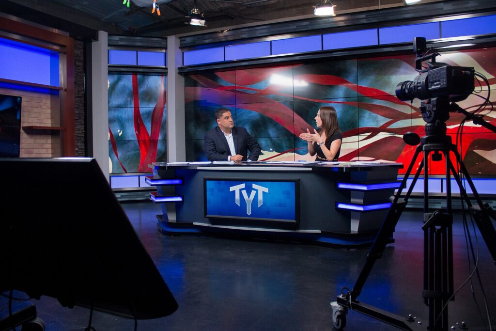 Ana Kasparian and Cenk Uygur hosting The Young Turks - tytvault, CC BY-SA 2.0 <https://creativecommons.org/licenses/by-sa/2.0>, via Wikimedia Commons