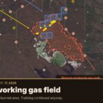 Satellite map of the CFB Wainwright fire area showing yellow fire detections and a red dashed burned area between two lakes, with red diamonds marking producing gas wells around it, under the headline "The fire and the gas wells."
